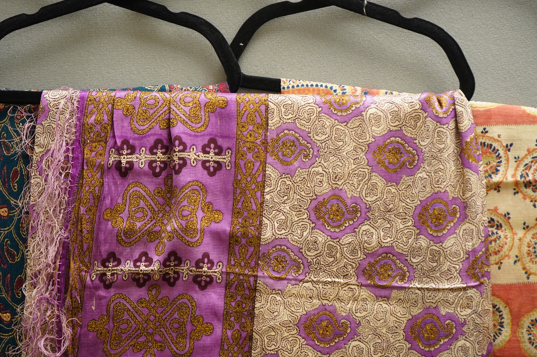 A 19th century printed silk shawl and a printed paisley shawl, together with a late 20th century wool machine woven stole with Oswal label. Condition - the two 19th century shawls are damaged but useful for TV and film c
